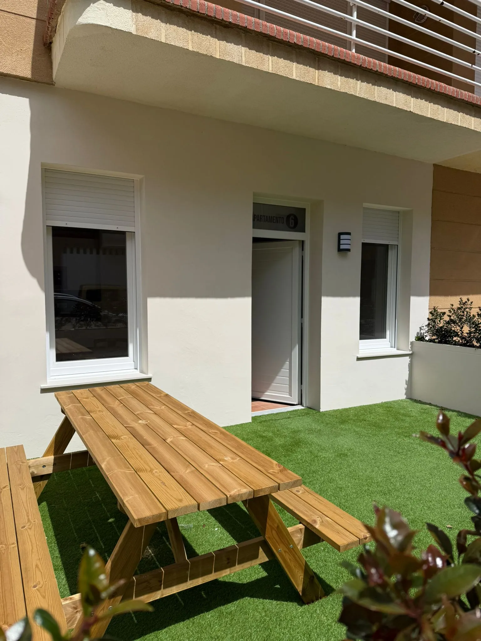 Private Terrasse mit Rasen und Picknicktisch aus Holz