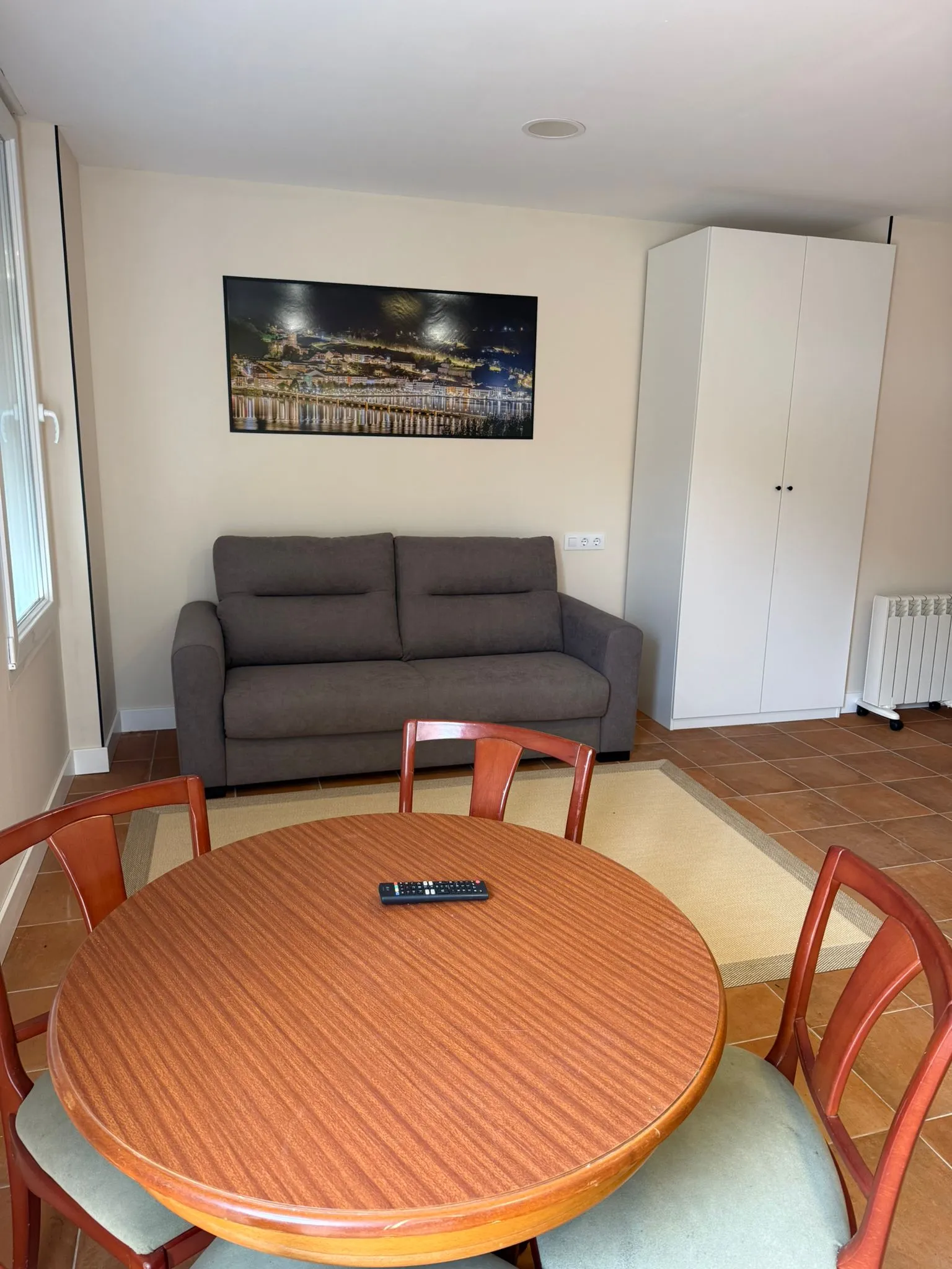 Wohnbereich des Studios mit Sofa und Kleiderschrank